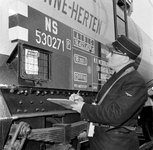 856397 Afbeelding van een ladingmeester van N.S. bij een ketelwagen voor het vervoer van chemicaliën van de Nepakris ...